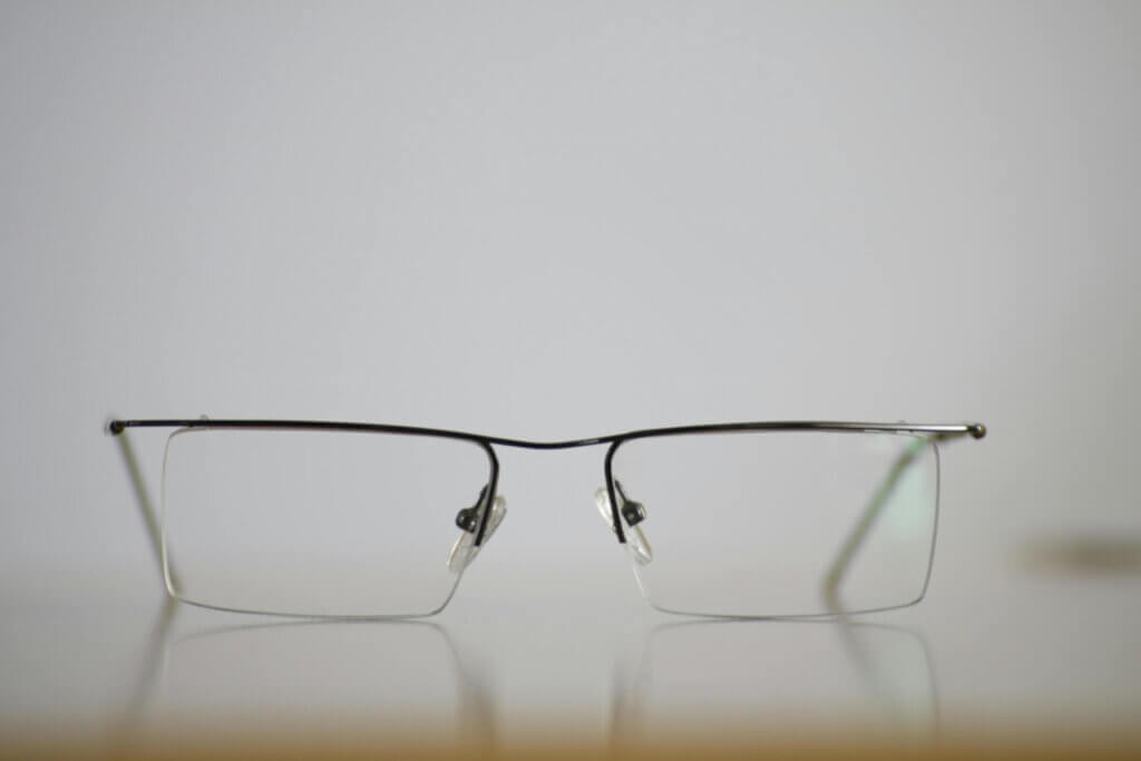 Photographie en gros plan d'une paie de lunettes ouvertes et posées sur une table
