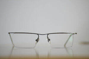 Photographie en gros plan d'une paie de lunettes ouvertes et posées sur une table